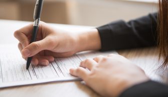 Cropped View of Woman Filling in Application Form