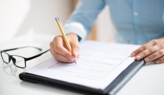 Closeup of business woman making notes in document