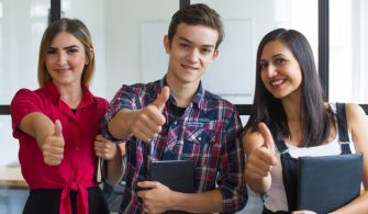 portrait-successful-young-students-showing-thumbs-up_1262-18009
