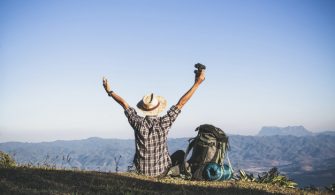 tourist-from-mountain-top-sun-rays-man-wear-big-backpack-against-sun-light_1150-9129