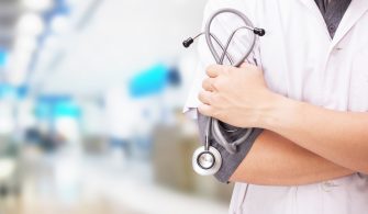 Doctor with a stethoscope in the hands and hospital background