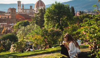 Girl sitting on the grass with a beautiful view of Florence at the background