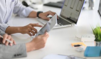 young-professional-ui-web-developer-working-his-project-with-laptop-computer-tablet_67155-4748