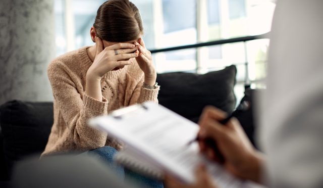 Depressed woman having psychotherapy session at doctor's office.