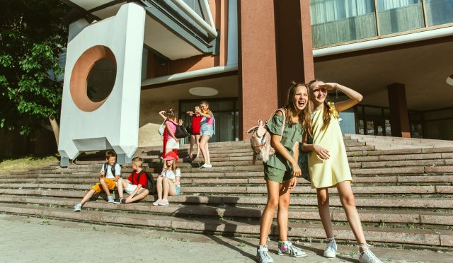 Happy kids playing at city's street in sunny summer's day