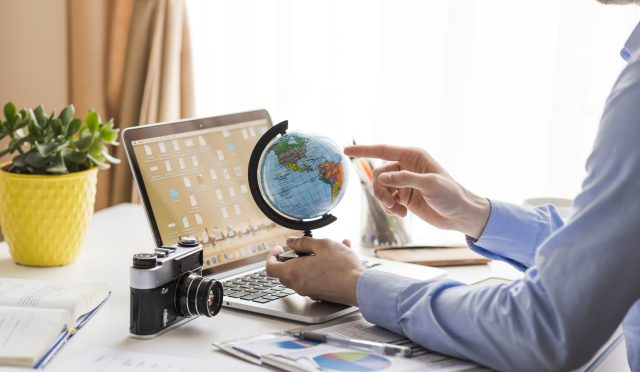 crop-man-pointing-globe-office