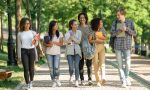 Multiethnic group of young cheerful students walking